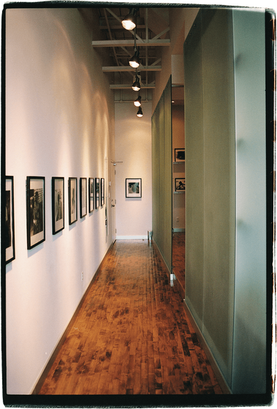 Narrow hallway with hard word floors, and images lining the walls